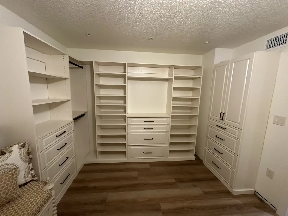 Custom walk-in closet with floor-to-ceiling shelving and banks of drawers