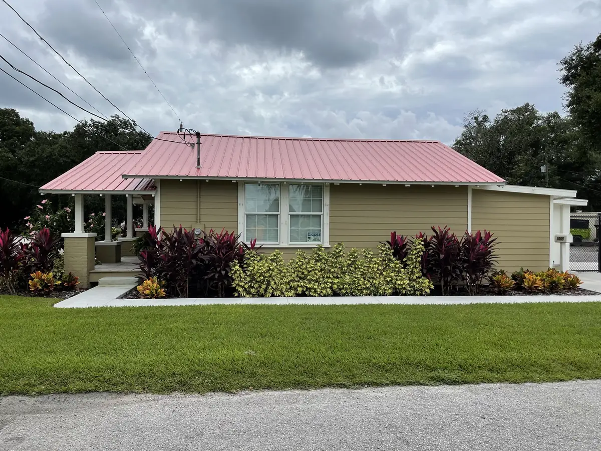 Exterior remodel with a new roof, fresh paint, and replanted beds along the walk