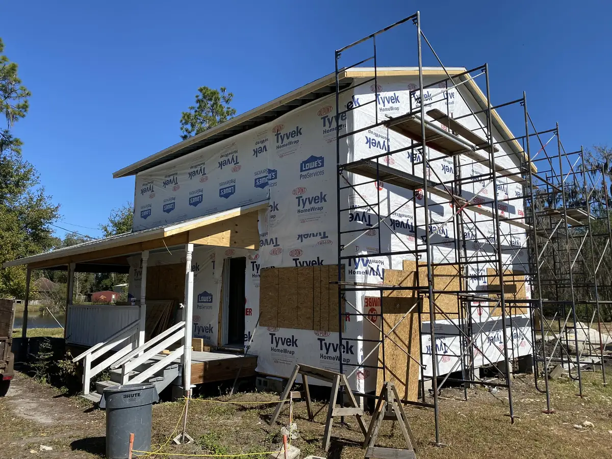 Second-storey addition going up over an existing single-storey house, sheathed and house-wrapped