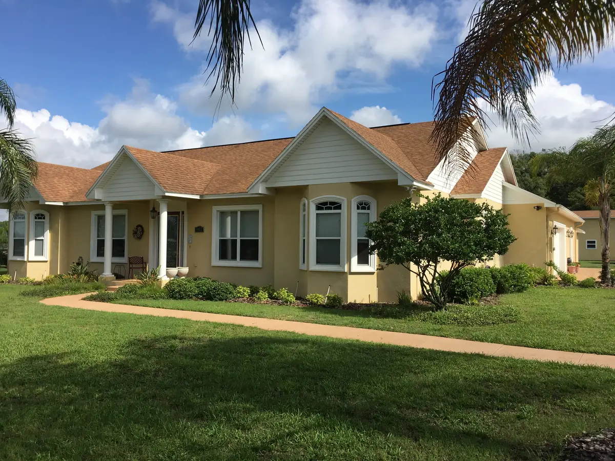 Finished stucco custom home framed by mature palms